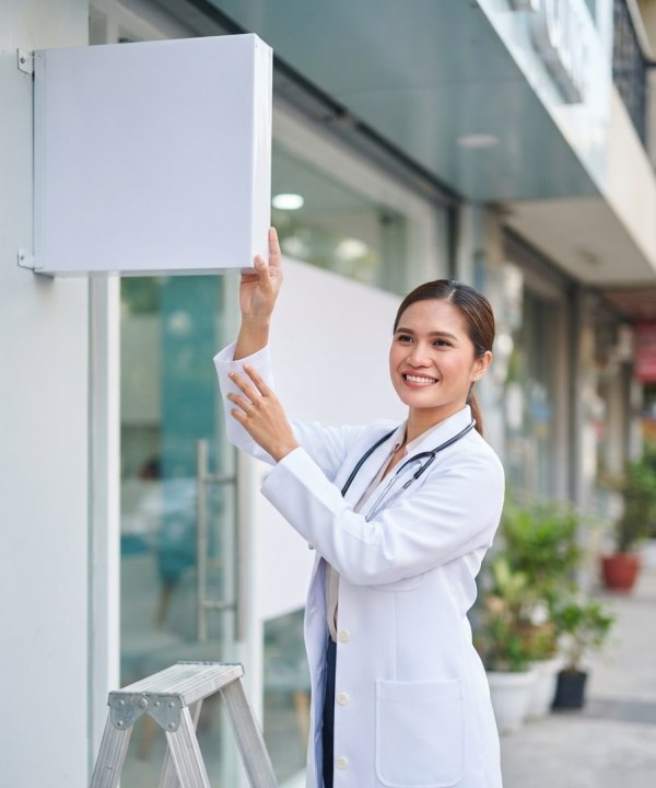 A doctor installing the signage of her new clinic
