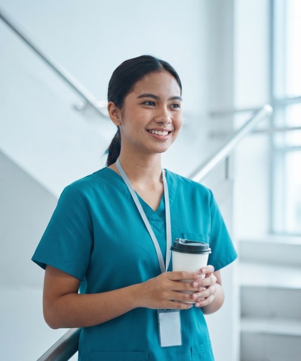 A resident on a coffee break in a bright hospital stairwell