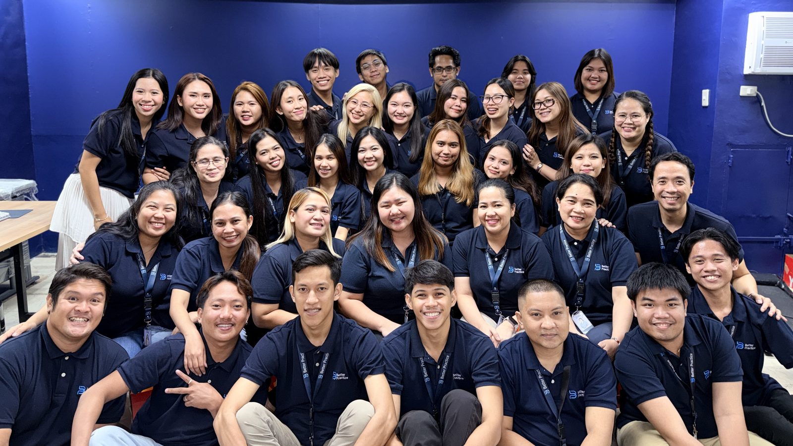 The whole Better Practice team in navy polo shirts at the office